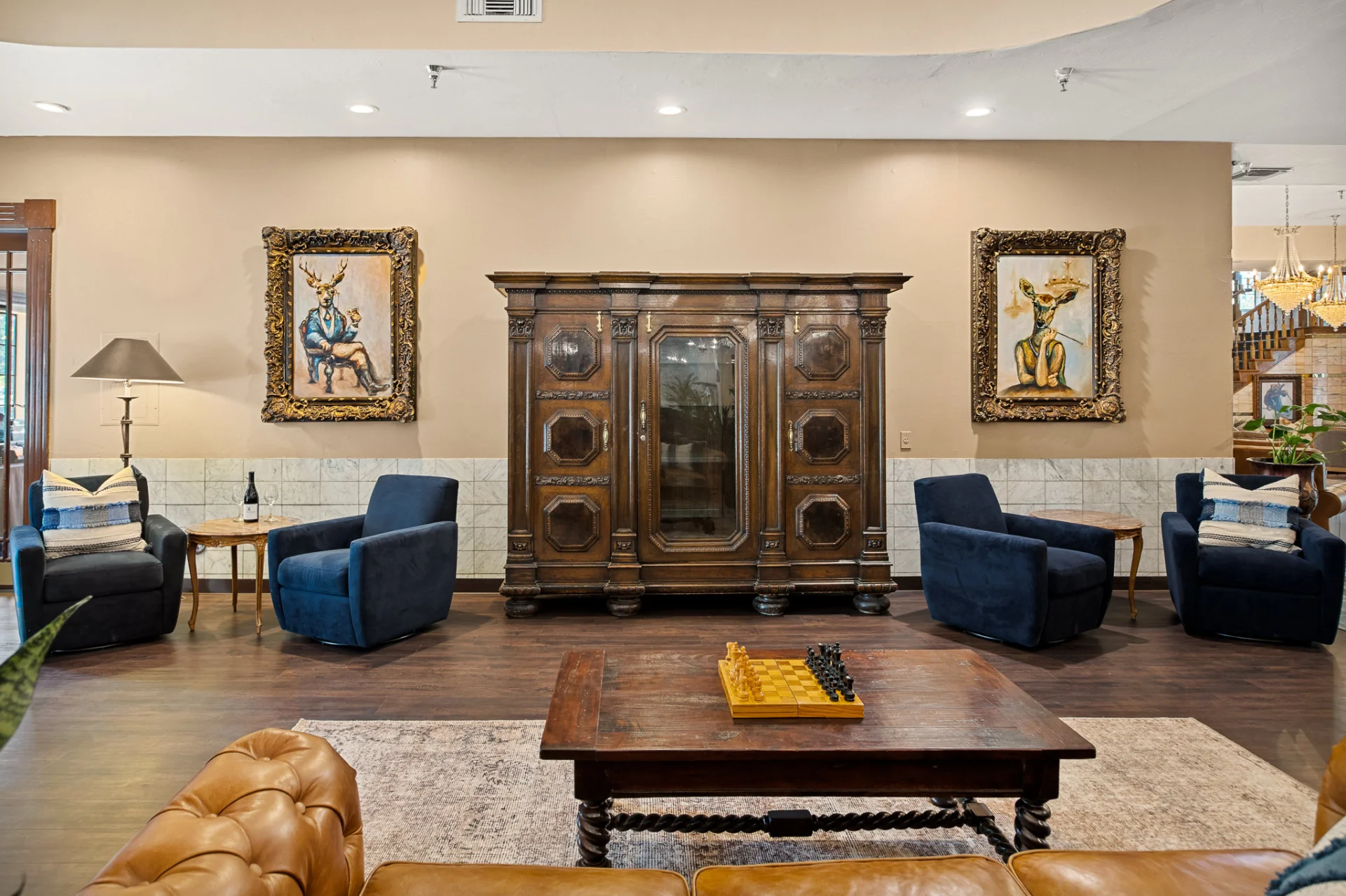 lounge area display case, chairs, and deer paintings